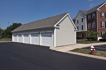 A garage with a red fire hydrant in front of it.